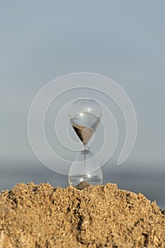 Hourglass on sea background. Transience of time concept. Vertical frame