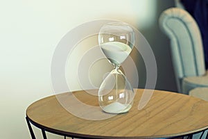 Hourglass standing on a table in a living room.