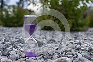 Hourglass on stones in a public park amid bushes