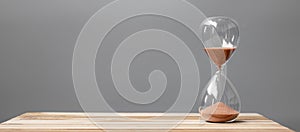 Hourglass on table office with copy space, Sand flowing through the bulb of Sandglass measuring the passing time. countdown,