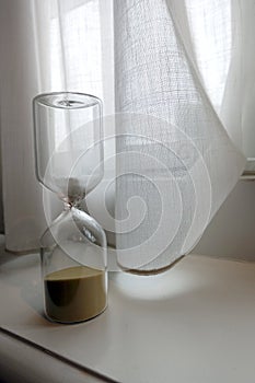 Hourglass on Windowsill with Curtain