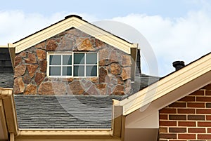 House adorned with a dormer on its roof, against the backdrop of a picturesque cloudy sky