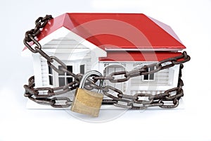 House arrest: locked down or quarantined concept of model home with chain and lock photo