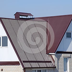 The house is with an attic and a combined roof. House with plastic windows and a brown roof of corrugated sheet