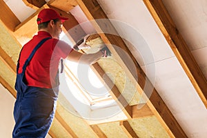 House attic insulation - construction worker installing wool photo