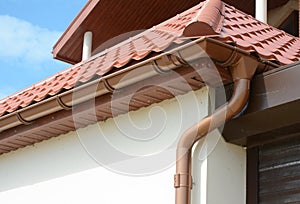 House attic metal roof with soffits, fascias, roof guttering, downspout gutter pipe. photo