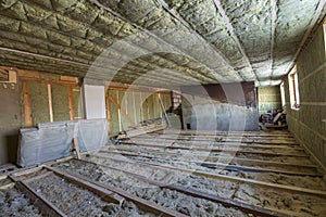 House attic under construction. Mansard walls and ceiling insulation with rock wool. Fiberglass insulation material in wooden fram