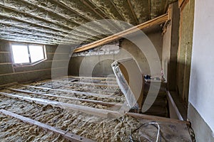 House attic under construction. Mansard walls and ceiling insulation with rock wool. Fiberglass insulation material in wooden fram