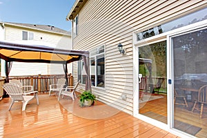 House Back porch with umbrella and chairs during rain.