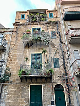 house with balconies and windows full of plants in Montemaggiore Belsito, Sicily, Italy