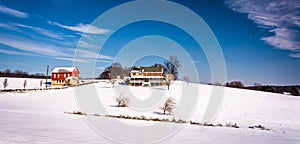 House and barn on snow covered farm fields in rural Carroll County, Maryland.