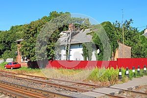 The house behind a red fence at the railroad