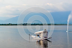 A House boat or Shikara boat ride on Dal lake Srinagar, Jammu and Kashmir, India. The Great Himalayas range are visible at a