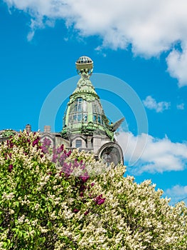 House of the Book on Nevsky Prospect in Saint Petersburg against the backdrop of blooming lilacs in summer