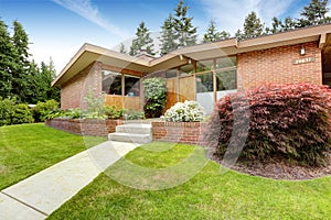 House with brick trim. Entrance porch and front yard view