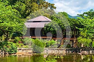 House built on stilts in the lush green tropical forest.