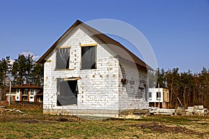 A house built of white brick with a black celofan on the windows photo