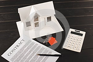 house buying concept with contract, keys, calculator and maquette over