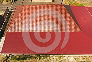 A house with a canopy over the courtyard. Roof from corrugated metal profile. Metal tiles.