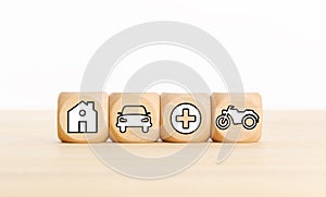 House, car, health and bike icons on wooden blocks Types of insurance concept