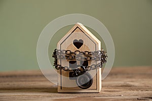 The house is chained and padlocked and stands on a wooden board, the concept of a ban on the sale of real estate, house