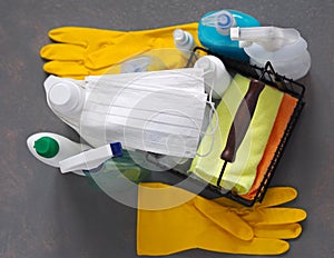 House cleaning concept.Plastic bottles with detergents and disinfectants on a gray background. The use of protective medical masks