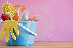 House cleaning product on wood table with pink background, home service or housekeeping concept