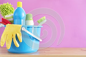 House cleaning product on wood table with pink background, home service or housekeeping concept