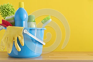 House cleaning product on wood table with yellow background, home service or housekeeping concept