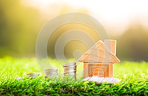 House and coins placed on grass. concept of real estate investment. planning savings money of coins to buy a home concept. concept