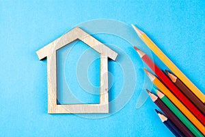 House and colored pencils on a blue background