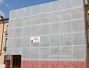 house completely covered with scaffolding and the protective net photo