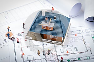 house construction project concept. building scale model and workers on blueprint