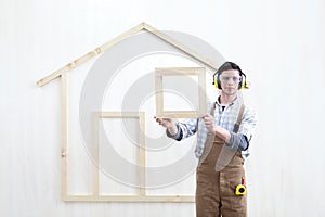 House construction renovation concept handyman carpenter worker man show the model of wooden house