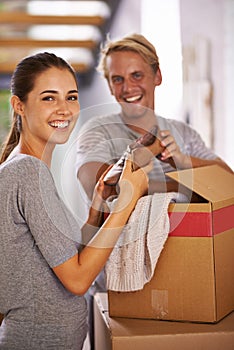 House, couple and smile with box for moving in with clothes, satisfied and property ownership. Family, people and