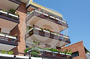 House decorated with flowers. Balcony of the multi-storey building decorated with a set of beautiful bright colors