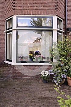 House decorated with many beautiful potted flowers, view from outside