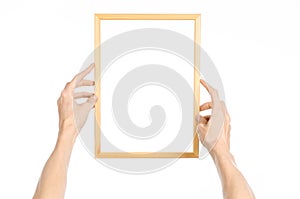 House decoration and Photo Frame topic: human hand holding a wooden picture frame isolated on a white background in the studio fir