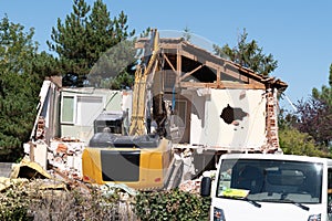 House demolition demolishing building with a large backhoe