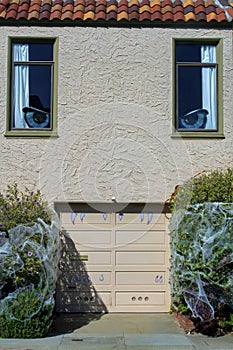 House designed to look like giante face or monster with eyes inside windows and teeth on garage door for halloween