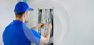 House electrical wiring - electrician working with cables in junction box. banner copy space