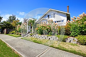 House with entance wooden archway and flower bed photo