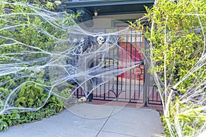 House entrance with fake webs and skeletons at the front of the iron gate in San Francisco, CA