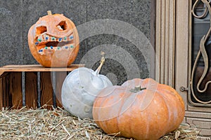 House entrance with halloween pumpkin decoration with spooky faces on porch of apartment building during all hallows eve