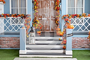 House entrance staircase decorated for autumn holidays, fall flowers and pumpkins