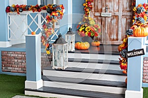 House entrance staircase decorated for autumn holidays, fall flowers and pumpkins.