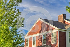 House exterior with rustic vinyl wood siding and chimney post with bricks at Daybreak, Utah