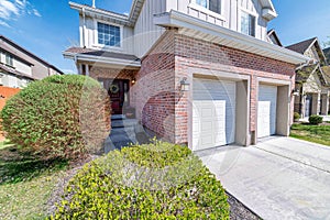 House facade with two car garage and front door with wreath and sidelights