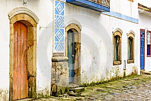 House facade in weather-damaged colonial architecture on cobblestone street