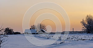 House and farm buildings in winter near Ostrowiec Swietokrzyski .